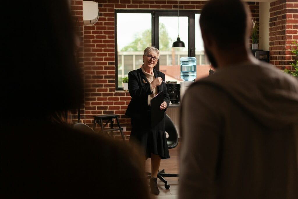 Woman psychiatrist greeting people at aa meeting program